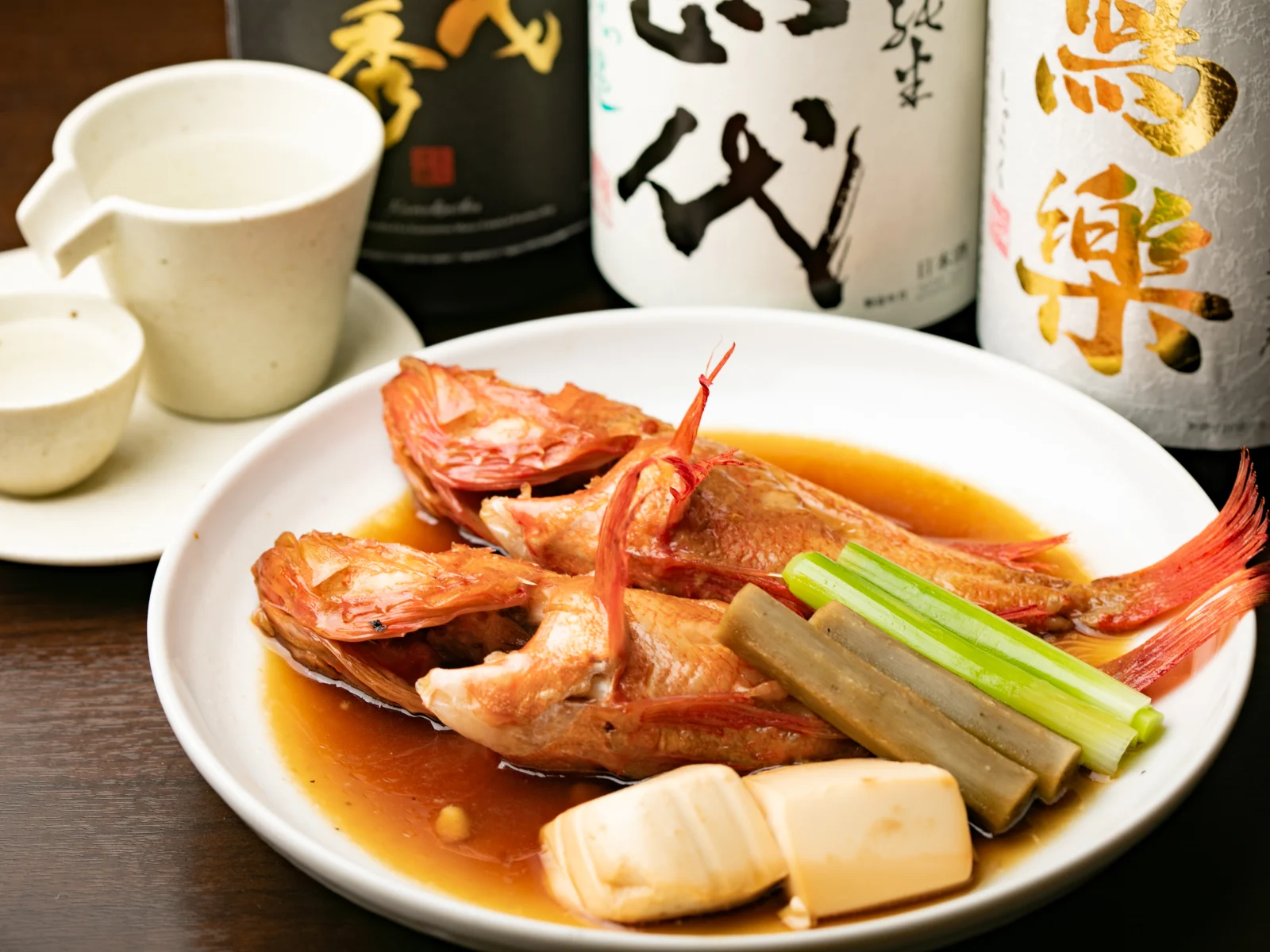 実際の煮魚と銘柄ラベルが見える日本酒