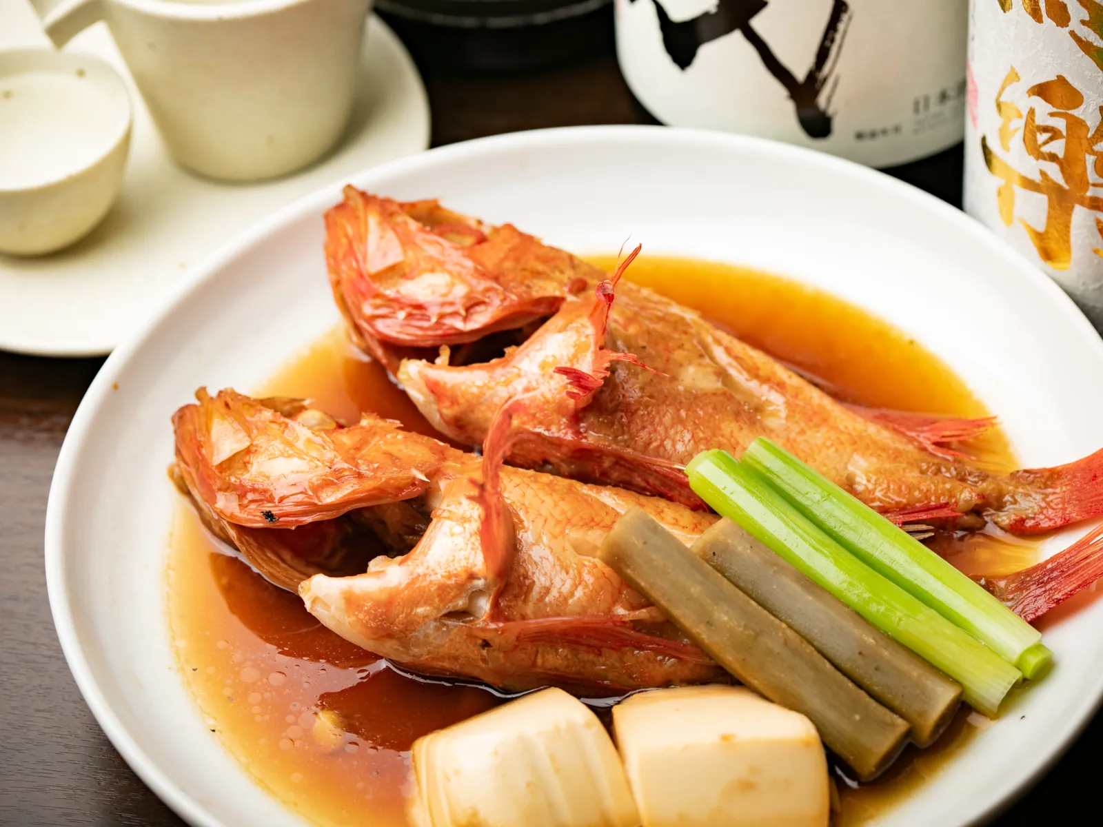 実際の煮魚と銘柄ラベルが見える日本酒